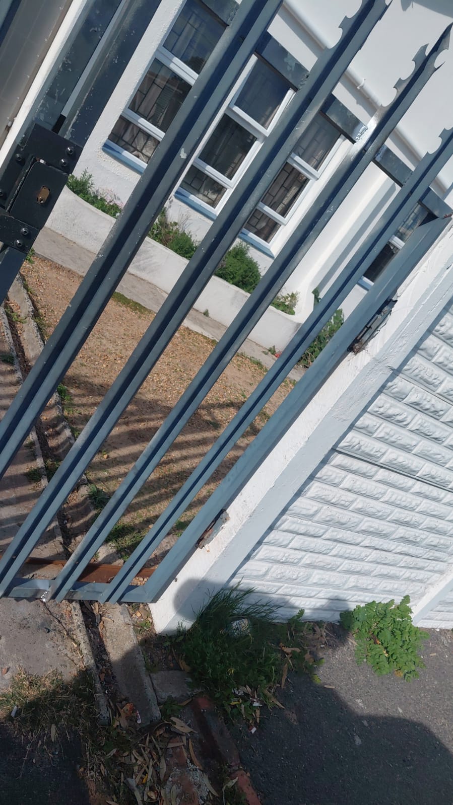 Detail of a freshly serviced black steel sliding gate panel